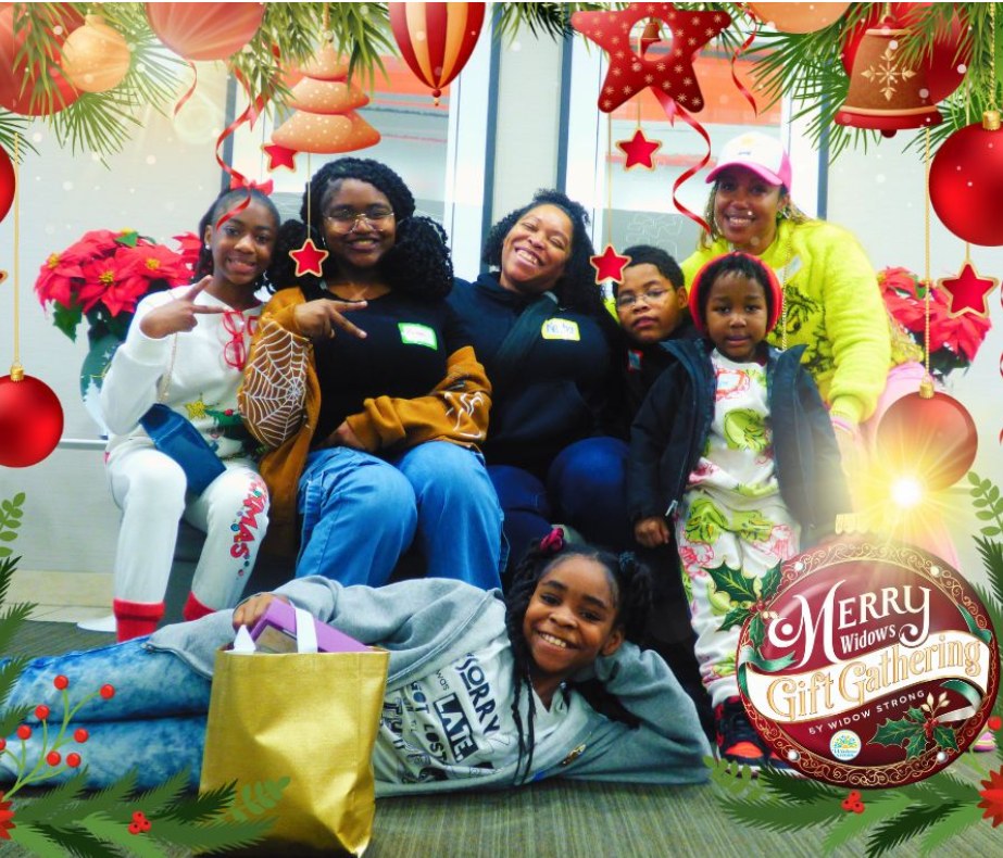 A family posing together in front of poinsettia plants inside a festive holiday photo frame