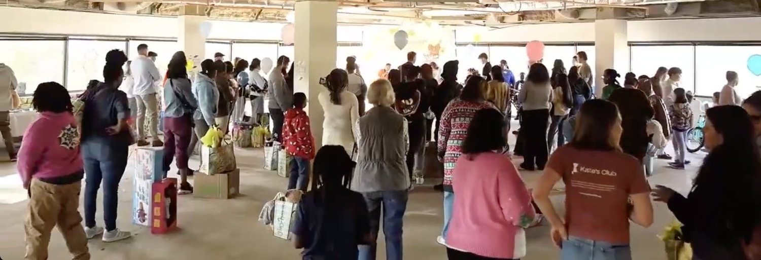 A full room of families, volunteers and staff gathered together inside the event space.